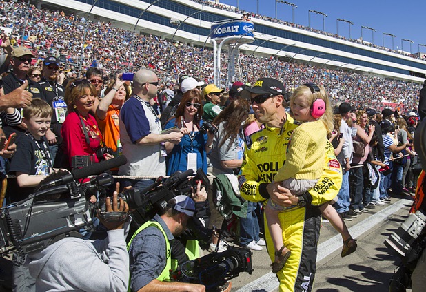 Diver Matt Kenseth carries his daughter Kaylin Nicola as he leaves a stage following driver introductions during the Kobalt Tools 400 NASCAR race at the Las Vegas Motor Speedway Sunday, March 10, 2013. Kenseth won the race.