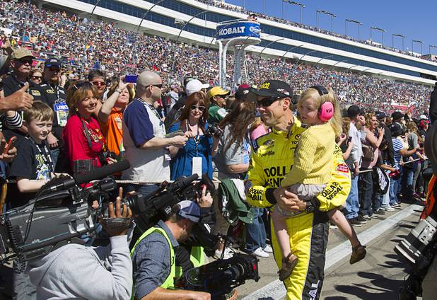 Diver Matt Kenseth carries his daughter Kaylin Nicola as he leaves a stage following driver introductions during the Kobalt Tools 400 NASCAR race at the Las Vegas Motor Speedway Sunday, March 10, 2013. Kenseth won the race.