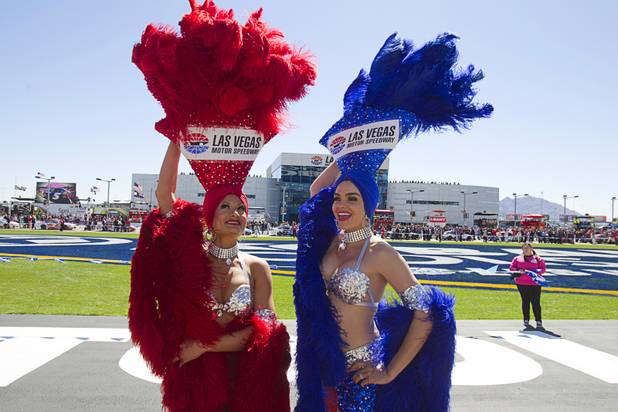 Showgirls Stacey Shea, left, and Porsha Revesz hold on to their headpieces as a light wind blows before the Kobalt Tools 400 NASCAR race at the Las Vegas Motor Speedway Sunday, March 10, 2013.