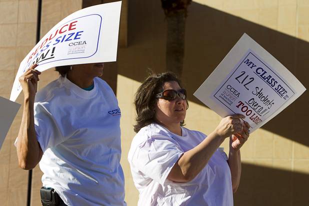 Amy De Vaul, right, an English teacher at Spring Valley High School, listens to speaks during a news conference outside the Sawyer State Building Wednesday, March 13, 2013. De Vaul said that teachers in the high school with five classes have an average of 212 students. Teachers, parents and union members held the rally as legislators were meeting in a joint assembly and senate committee meeting to discuss education issues.
