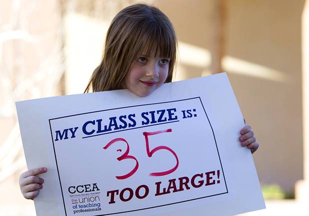 Kindergartener Sherri Wolfe, 6, holds a sign as teachers, including her mother, rally for smaller class sizes outside the Sawyer State Building Wednesday, March 13, 2013. Teachers, parents and union members held the rally as legislators were meeting in a joint assembly and senate committee meeting to discuss education issues.