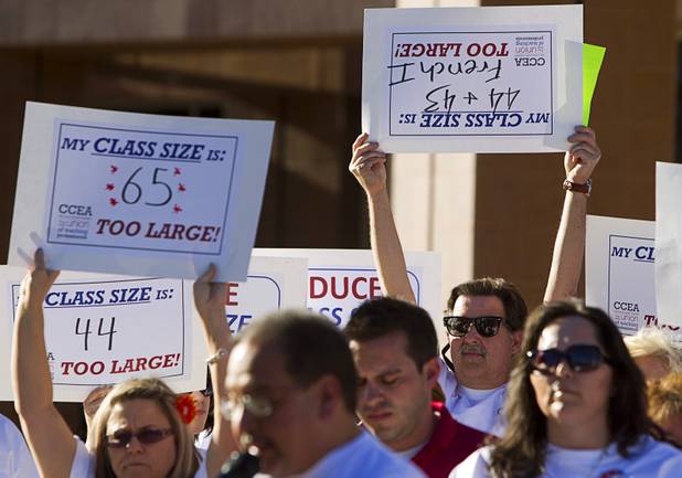Clark County School District teachers hold up signs during a news conference outside the Sawyer State Building Wednesday, March 13, 2013. Teachers, parents and union members held the rally as legislators were meeting in a joint assembly and senate committee meeting to discuss education issues.