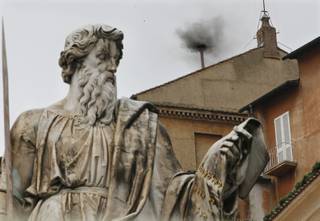 Black smoke emerges from the chimney on the Sistine Chapel as cardinals voted on the second day of the conclave to elect a pope in St. Peter's Square at the Vatican, Wednesday, March 13, 2013. In the foreground is the statue of St. Paul. 