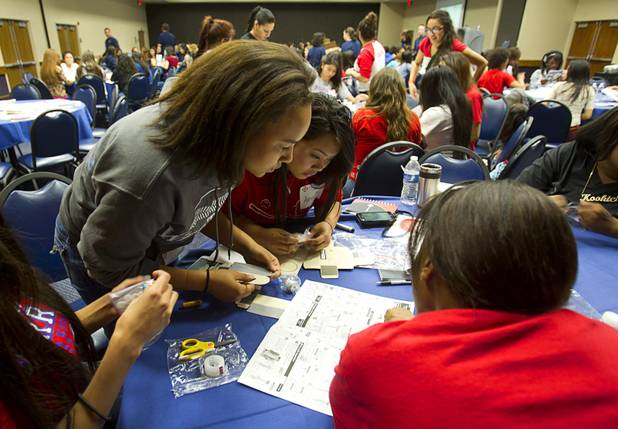 Students from Western High School read directions on how to assemble a robot kit during the annual HerWorld workshop at the Henderson Convention Center Thursday, March 14, 2013. About 230 students attended the workshop, sponsored by DeVry University, intended to introduce female high school students to careers in science, technology, engineering and math.