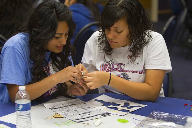 Gabriela Arias, left, and Alicia Reyes of Western High School assemble a wheel for a robot during the annual HerWorld workshop at the Henderson Convention Center Thursday, March 14, 2013. About 230 students attended the workshop, sponsored by DeVry University, intended to introduce female high school students to careers in science, technology, engineering and math.