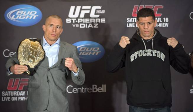 Mixed Martial Arts fighters Georges St-Pierre and Nick Diaz pose for the media following their news conference in Montreal on Thursday, March 14, 2013. The pair will meet in a UFC 158 title fight in Montreal on Saturday.