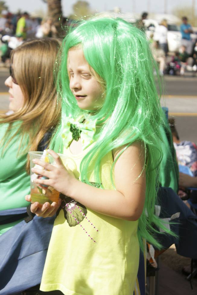 A girl wears a long green wig during the St. Patrick's Day Parade in downtown Henderson, Saturday, Mar. 16, 2013.