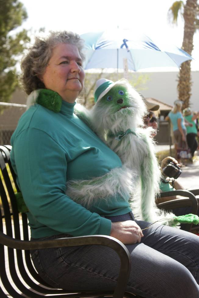 A parade goer with her green puppet watch the St. Patrick's Day Parade in downtown Henderson, Saturday, Mar. 16, 2013.