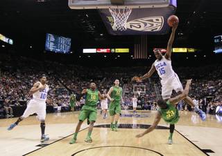 UCLA's Shabazz Muhammad collides with Oregon's Carlos Emory as he drives in for a basket in the first half of their NCAA college basketball game in the Pac-12 Conference tournament, Saturday, March 16, 2013, in Las Vegas. Muhammad was charged with an offensive foul on the play, and the UCLA bench was charged with a technical foul. (AP Photo/Julie Jacobson)