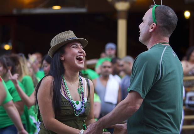 A couple dances outside Hennessey's Tavern on Fremont Street during St. Patrick's Day Sunday, March 17, 2013.