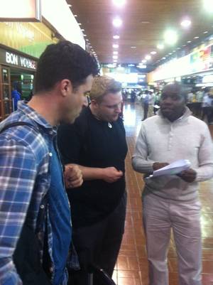 Frankie and Ricky Moreno at the Nairobi airport, discussing logistics with a driver named Dennis.