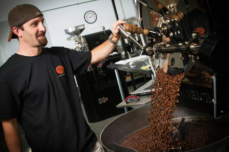 Colorado River Coffee Roasters buys raw coffee beans from importers, roasts them on site and packages and distributes them to cafes, restaurants and retailers. Above, roaster Erik Anderson processes beans at the company's Boulder City headquarters.