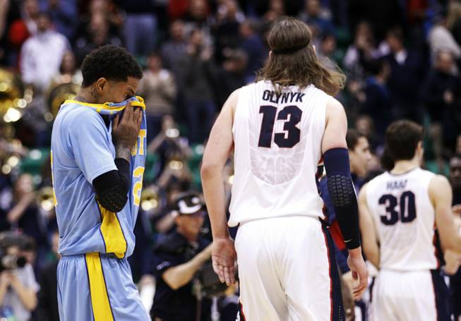 Southern University's Derick Beltran (2) pulls his jersey to his face as Gonzaga's Kelly Olynyk (13) walks off the court at the end of their second-round game in the NCAA college basketball tournament in Salt Lake City, Thursday, March 21, 2013. Gonzaga won 64-58. 