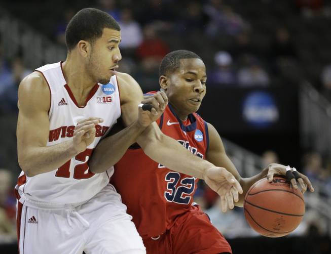 Mississippi guard Jarvis Summers (32) is fouled by Wisconsin guard Traevon Jackson (12) during the first half of a second-round game in the NCAA college basketball tournament at the Sprint Center in Kansas City, Mo., Friday, March 22, 2013.