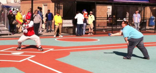 A Miracle League player prepares to hit an incoming pitch.