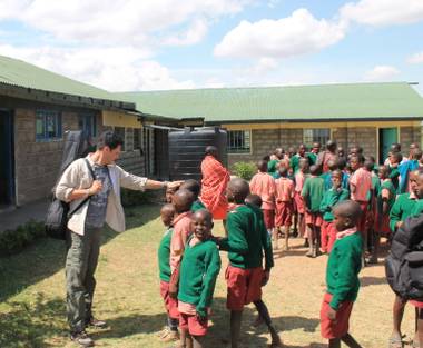 Stratosphere headliner Frankie Moreno pats the heads of children at Oloibormurt Primary School in Kenya’s Maasai Mara region.