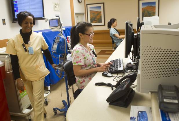 Nurse Tristan Tran, center, works at a nurse's station at Sunrise Hospital Monday, March 25, 2013. Also pictured are nurse's assistant Ghennet Haile, left, and Cristiana Saito, a physical therapy student. 