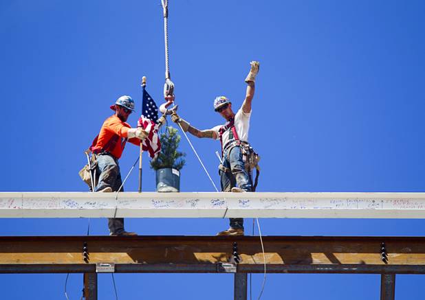 Ironworkers Jeff Koch, left, Mike Dyke signal to a crane operator after securing the final steel beam during a topping-out ceremony for the Federal Justice Tower in downtown Las Vegas Wednesday, March 27, 2013. The new 11-story tower, just to the south of the Lloyd D. George Federal Courthouse on Las Vegas Boulevard, will house the executive and administrative offices of the Department of Homeland Security, U.S. Immigration, U.S. Attorney's Office for the District of Nevada, the Department of Labor Office of Inspector General and the Federal Protective Services.