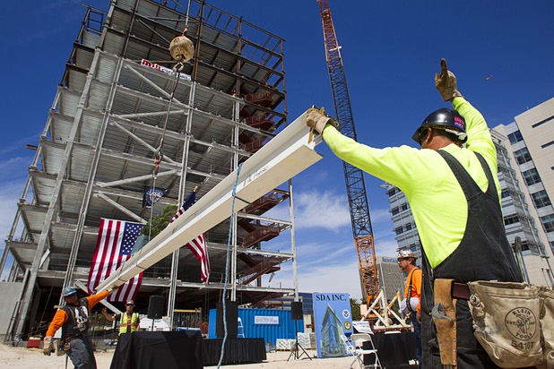 An ironworker signals to a crane operator as the final beam is lifted during a topping-out ceremony for the Federal Justice Tower in downtown Las Vegas Wednesday, March 27, 2013. The new 11-story tower, just to the south of the Lloyd D. George Federal Courthouse on Las Vegas Boulevard, will house the executive and administrative offices of the Department of Homeland Security, U.S. Immigration, U.S. Attorney's Office for the District of Nevada, the Department of Labor Office of Inspector General and the Federal Protective Services.