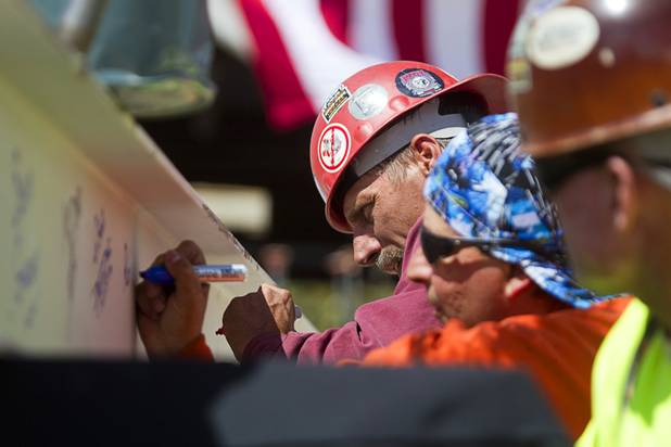 Ironworker Mathew Bylund signs the final beam during a topping-out ceremony for the Federal Justice Tower in downtown Las Vegas Wednesday, March 27, 2013. The new 11-story tower, just to the south of the Lloyd D. George Federal Courthouse on Las Vegas Boulevard, will house the executive and administrative offices of the Department of Homeland Security, U.S. Immigration, U.S. Attorney's Office for the District of Nevada, the Department of Labor Office of Inspector General and the Federal Protective Services.