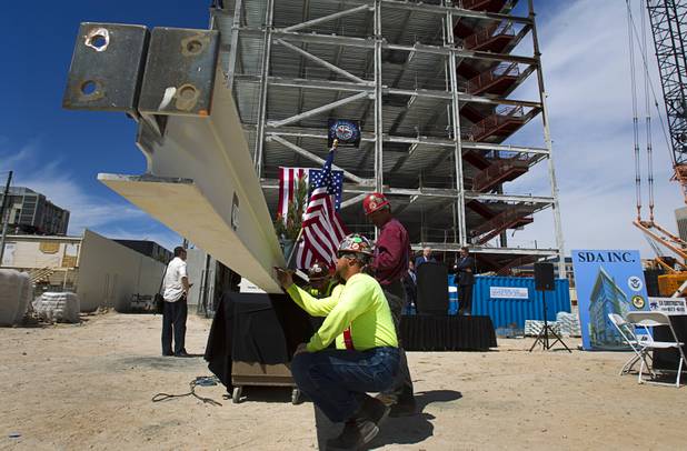 An ironworker signs the final steel beam during a topping-out ceremony for the Federal Justice Tower in downtown Las Vegas Wednesday, March 27, 2013. The new 11-story tower, just to the south of the Lloyd D. George Federal Courthouse on Las Vegas Boulevard, will house the executive and administrative offices of the Department of Homeland Security, U.S. Immigration, U.S. Attorney's Office for the District of Nevada, the Department of Labor Office of Inspector General and the Federal Protective Services.