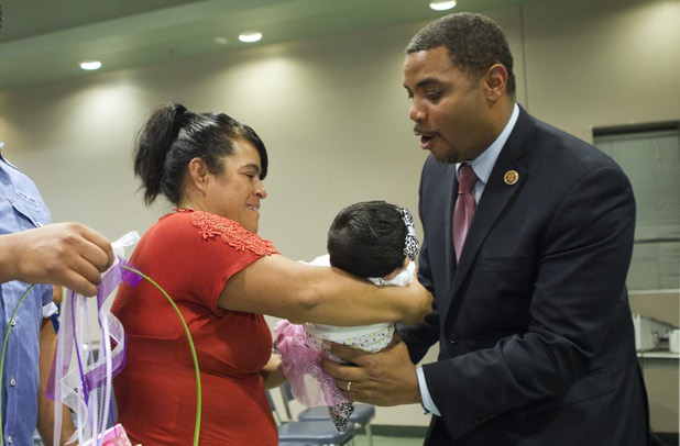Ivon Meneses hands her daughter Ruby, two-months, to Congressman Steven Horsford (D-NV) during a town hall meeting at the Cora Coleman Senior Center in Las Vegas Thursday, March 28, 2013. Horsford will have a meet and greet at 7222 W. Grand Teton Ave. on Saturday.