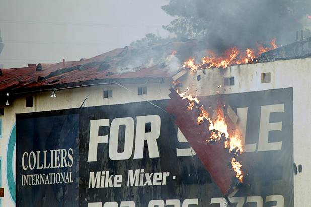 A piece of the roof falls as Clark County and City of Las Vegas firefighters battle a four-alarm fire at the old Key Largo Casino on Flamingo Avenue and Paradise Road Thursday, March 28, 2013.