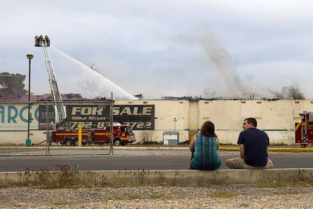 A couple watches as Clark County and City of Las Vegas firefighters battle a four-alarm fire at the old Key Largo Casino on Flamingo Avenue and Paradise Road Thursday, March 28, 2013.