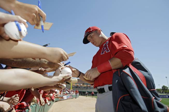 Los Angeles Angels' Mike Trout signs for fans before an exhibition spring training baseball game against the Chicago White Sox Monday, March 25, 2013, in Glendale, Ariz.