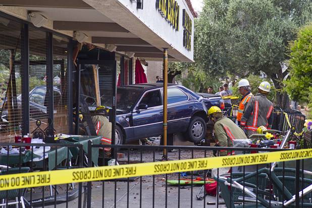 Firefighters look over a car after making rescues at the Egg and I restaurant on West Sahara Avenue Monday April 1, 2013. As many as 10 people were injured when a Lexus sedan left the roadway and crashed into the restaurant.