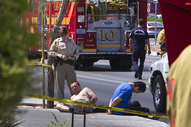 Two men appear to be detained by Metro Police after an accident at the Egg and I restaurant on West Sahara Avenue Monday April 1, 2013. As many as 10 people were injured when a Lexus sedan left the roadway and crashed into the restaurant.