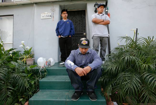 From left, Ruben Fernandez, 15, and his brothers Robert, 22, and Anthony, 18, mourn the loss of their father, Leonardo Fernandez, on the front steps of his home in Los Angeles, California, on April 1, 2013. Leonardo Fernandez, 45, his brothers, Genaro Fernandez, 41, and Raudel Fernandez, 49, were among five people killed when their van was struck by a suspected drunk driver in Nevada while making their way back to Los Angeles after visiting a sick relative in Denver, Colorado.