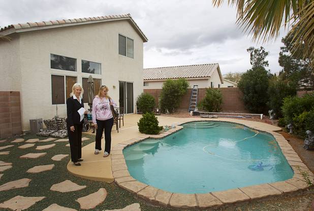 Fafie Moore, left, a Realty Executives owner/broker, and Realtor Helen Riley look over the backyard of a home being offered for sale in Henderson on April 8, 2013.