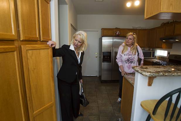 Fafie Moore, left, a Realty Executives owner/broker, and realtor Helen Riley look over a home being offered for sale in Henderson April 8, 2013.
