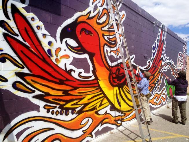 Garrison and Alison Buxton of Londonderry, Vt., add the finishing touches to a mural on the rear of the Huntridge Theater in downtown Las Vegas. The mural of a phoenix gives rise to suggestions the theater may be undergoing a rebirth.