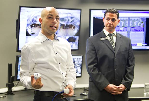 Christian Petrou, left, CEO and founder of Rvnue Technologies, holds Mobotix security cameras in the Security Operations Center during a hi-tech security tour of the Panorama Towers Wednesday, April 10, 2013. Security Director River Polson listens at right. The tour was held in conjunction with the International Security Conference & Exposition (ISC West)  taking place at the Sands Expo Center.
