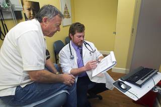 Gerry Eirkl of Henderson looks over a list of providers with Physician Assistant Brian Ekberg at a  Southwest Medical Associates clinic inside a Walmart, 300 E. Lake Mead Pkwy., in Henderson Thursday, April 11, 2013.