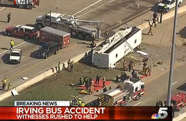 This frame grab provided by KXAS-TV shows emergency personnel at the scene where a chartered bus overturned on a highway near Dallas-Fort Worth International Airport in Irving, Texas.  Authorities say at least six people are hospitalized.