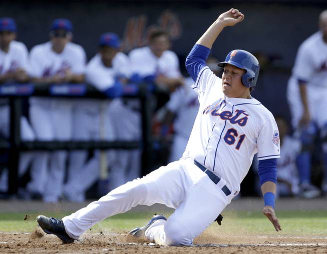 New York Mets' Wilmer Flores scores on a hit by Justin Turner and a throwing error by Houston Astros left fielder Fernando Martinez during the fourth inning of a spring training baseball game Saturday, March 9, 2013, in Port St. Lucie, Fla. 
