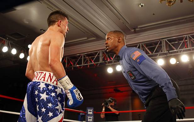 Referee Kenny Bayless checks on Angelo "La Cobra" Santana of Cuba after he was knocked down by Bahodir "Baha" Mamadjonov of Uzbekistan in the ninth round of their WBA lightweight bout at the Treasure Island Friday, April 12, 2013.