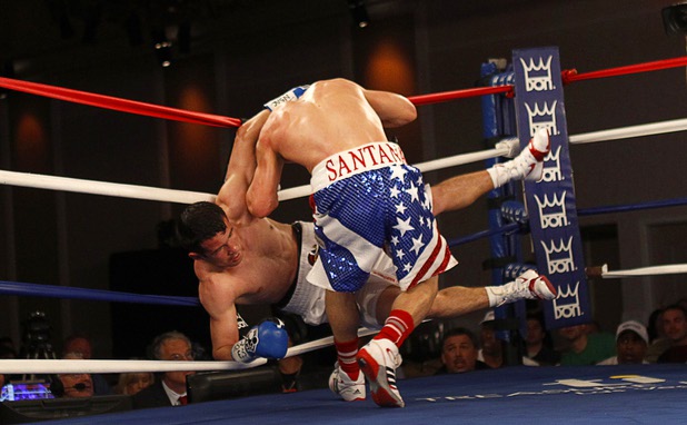 Bahodir "Baha" Mamadjonov, left, of Uzbekistan falls into the ropes during a WBA lightweight bout against Angelo "La Cobra" Santana of Cuba at the Treasure Island Friday, April 12, 2013.