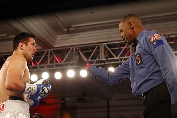Referee gives a count to Bahodir "Baha" Mamadjonov of Uzbekistan after he was knocked down by Angelo "La Cobra" Santana of Cuba during a WBA lightweight bout at the Treasure Island Friday, April 12, 2013.