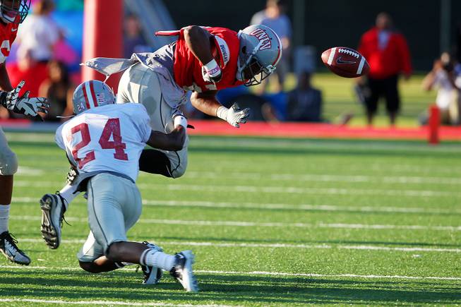 UNLV running back Adonis Smith loses the ball after being hit by Fred Wilson during their spring football game Friday, April 12, 2013.