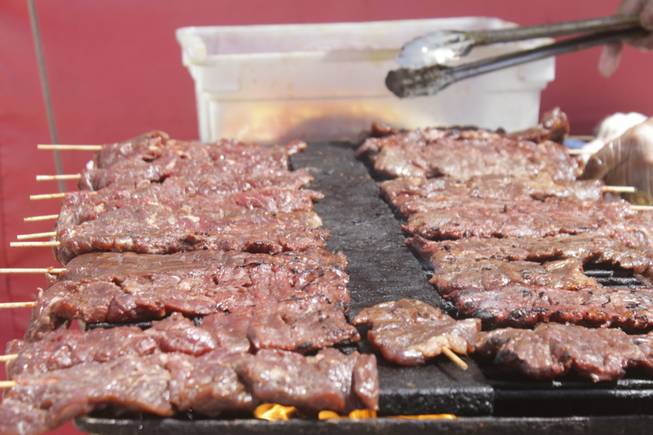 A cook grills beef on a stick at the 2013 Clark County Fair, Saturday, April 13, 2013.