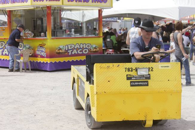 A man wearing a cowboy hat takes time to check his phone at the 2013 Clark County Fair, Saturday, April 13, 2013.
