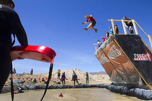 A competitor leaps from the "Walk the Plank" obstacle during the Tough Mudder in Beatty, Nev. Sunday, April 14, 2013. Tough Mudder events are hardcore 10-12 mile obstacle courses designed to test all-around strength, stamina, mental grit, and camaraderie.