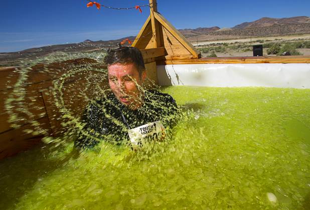 A man surfaces as he makes his way through the "Arctic Enema" during the Tough Mudder in Beatty, Nev. Sunday, April 14, 2013. Tough Mudder events are hardcore 10-12 mile obstacle courses designed to test all-around strength, stamina, mental grit, and camaraderie.