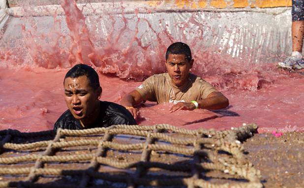 Competitors make their way through the "Firewalker" obstacle during the Tough Mudder in Beatty, Nev. Sunday, April 14, 2013. Tough Mudder events are hardcore 10-12 mile obstacle courses designed to test all-around strength, stamina, mental grit, and camaraderie.