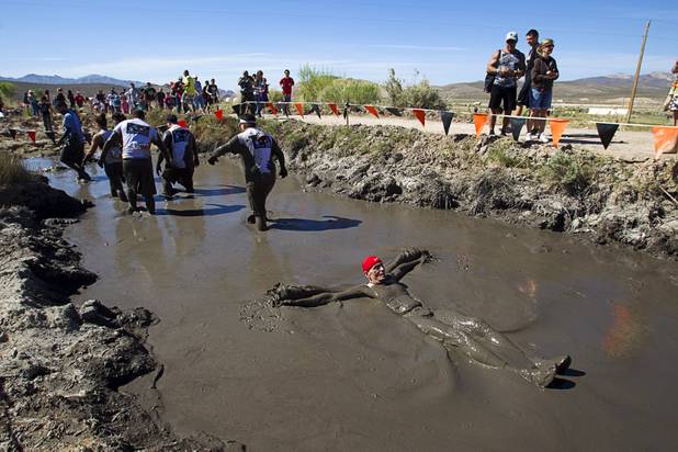 Michael Carroll of Las Vegas finds a different way to get through the mud during the Tough Mudder in Beatty, Nev. Sunday, April 14, 2013. Tough Mudder events are hardcore 10-12 mile obstacle courses designed to test all-around strength, stamina, mental grit, and camaraderie.