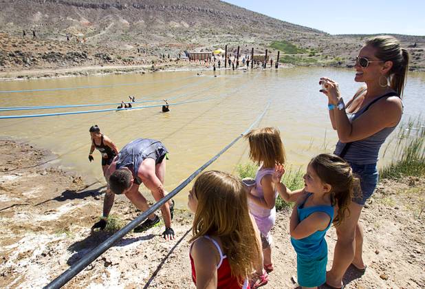 Ira Green and her daughters cheer on her husband Daniel (just out of the frame) during the Tough Mudder in Beatty, Nev. Sunday, April 14, 2013. Tough Mudder events are hardcore 10-12 mile obstacle courses designed to test all-around strength, stamina, mental grit, and camaraderie.